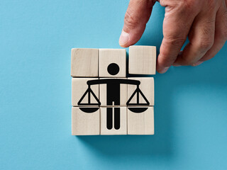 Male hand arranging wooden cubes with business ethics or justice icon.