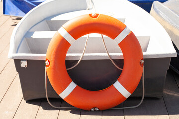 Pier with lifebuoy and boat. Boats for walking. Boats rental. Relax in the summer
