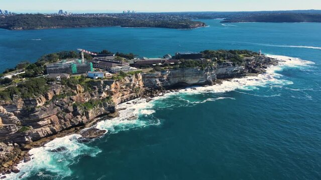 Aerial drone view of Watsons Bay in East Sydney, Australia heading north along the coastal clifftop and walkway toward South Head on a sunny day