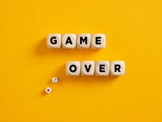 The word game over on wooden cubes with gaming dice. Failure, loosing or gambling