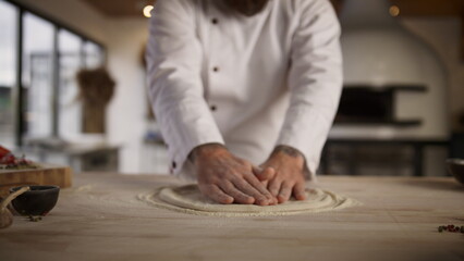 Culinary chef cooking pizza dough in restaurant kitchen. Pastry recipe concept.