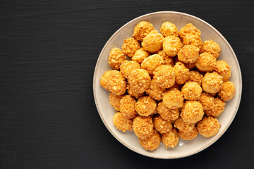 Homemade Crumbly Biscuits with Parmigiano Reggiano on a Plate on a black background, top view. Flat lay, overhead, from above.