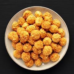 Homemade Crumbly Biscuits with Parmigiano Reggiano on a Plate on a black background, top view. Flat lay, overhead, from above.