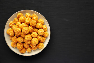 Homemade Crumbly Biscuits with Parmigiano Reggiano on a Plate on a black surface, top view. Flat lay, overhead, from above. Copy space.