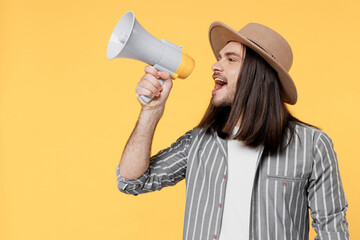 Young man he wears striped grey shirt white t-shirt hat hold scream in megaphone announces discounts sale Hurry up isolated on plain yellow color background studio portrait. People lifestyle concept.