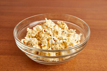 Large transparent bowl filled with popcorn.