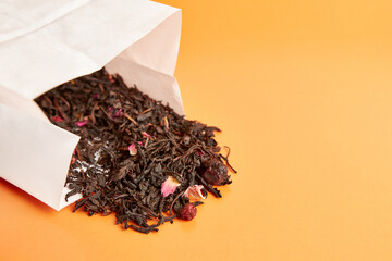 Paper bag with fruit tea on a wooden background.