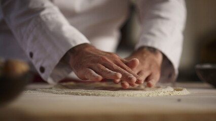 Fototapeta na wymiar Baker hands cooking dough pizza on flour wooden board in kitchen restaurant.