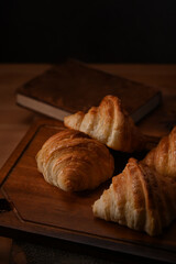 Tasty butter croissants on wooden table. Levitation, bread bakery products cafe concept