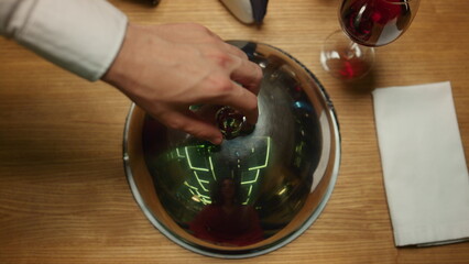 Fine restaurant dish lid cloche on table. Waiter hand presenting dinner meal.