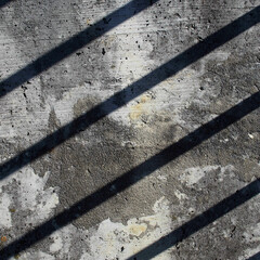 Pared de cemento con una sombra de rayas en diagonal.   Formato cuadrado. Fondo.