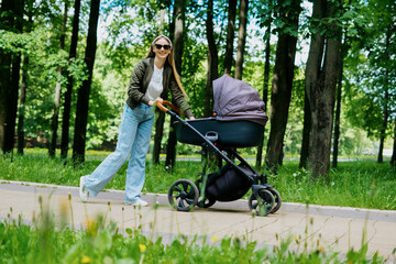 Fototapeta na wymiar Motherhood, a walk in the park, a young mother