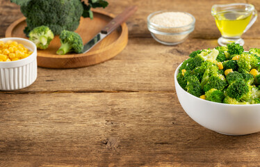 Salad of broccoli with ingredients on wooden background. Copy space.