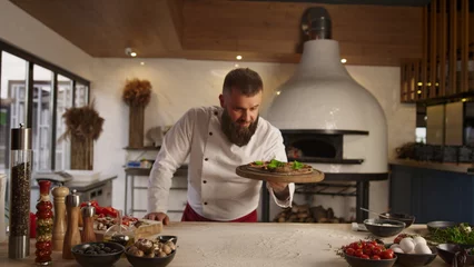 Fototapeten Pizza cook man presenting traditional italian food recipe in restaurant kitchen. © stockbusters