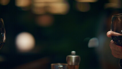 Couple clinking wine glasses in romantic restaurant bar. Dinner date concept.