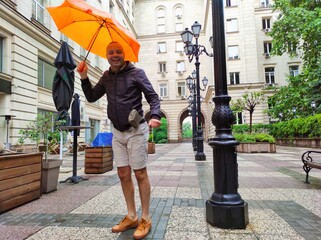 Man walking in the city on rain with umbrella
