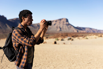 Young man taking pictures on a road trip. Man making memories on the mountain.