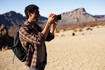 Young man taking pictures on a road trip. Man making memories on the mountain.