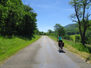 Jeune femme à vélo et bicyclette avec sacoche en cyclotourisme sur les pistes cyclables et voies vertes du sud de la France région Occitanie montagne Noire Lacaune Espinouse 