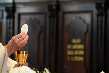 Priest showing the host during the mass - obrazy, fototapety, plakaty