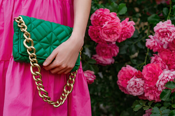Fototapeta na wymiar Summer fashion details: trendy green faux leather bag, handbag with chunky chain in stylish women's outfit. Copy, empty space for text