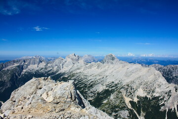 Landscape image of mountains in the Slovenian Julian Alps and western Julian alps in Italy. The main peaks in the image are from left to right Jalovec, Jof di Montasio and Mangart.