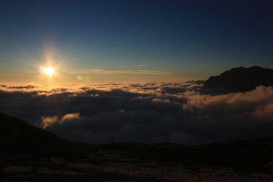 Early morning, amber sunrise in the mountains above the clouds. Image taken in the fall.