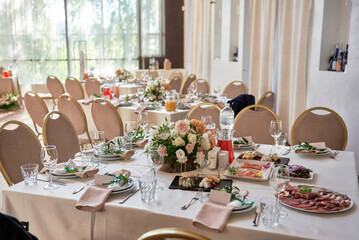 Table setting with sparkling wineglasses, plate with beige napkin and cutlery on table, copy space. Place set at wedding reception. Table served for wedding banquet in restaurant