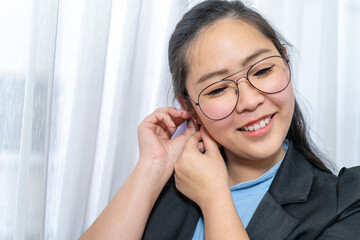 Close up to Beautiful Asian Woman face with her polite glasses in business suit in private room.