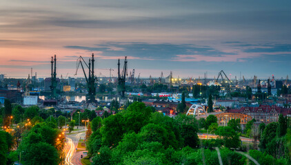 Fototapeta na wymiar Shipyard cranes in Gdansk at sunset. Poland