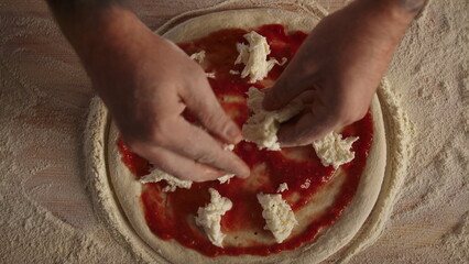 Man cook making pizza pepperoni on flour board kitchen table at restaurant.