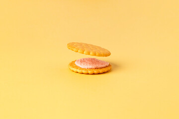 The concept of parsing cookies into their constituent ingredients. Split cookies with fruit filling on a yellow background. Light background. Close-up. Side view