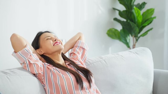 Asian beautiful girl lying down on comfort sofa in living room at home. 