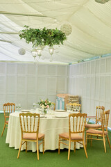Table setting with blank guest card, plates with napkins and cutlery, copy space. Place setting at wedding reception. Round table served for banquet in restaurant