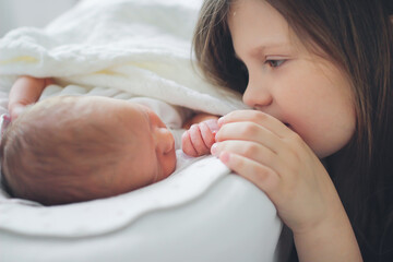 newborn child, together with a sibling sister, peacefully and gently touches. Gentle innocent baby...