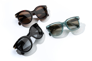 Set of Stylish sunglasses with bright sunlight on white background. Front, top view. Summer...