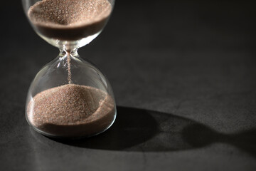hourglass (sand clock) on a black background, Hourglass as time passing concept for business deadline, Life-time passing concept, elapsed time concept, with copy space