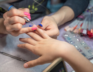 the procedure of a hardware manicure for a girl in a close-up in a beauty salon