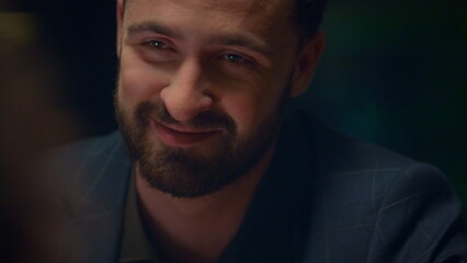 Obraz premium Happy man talking smiling in romantic light restaurant. Date chatting concept.