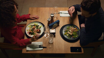 Two people enjoy dinner in loft restaurant. Couple celebrate anniversary in cafe