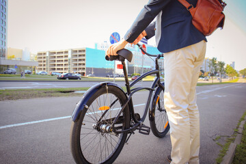 Confident young businessman walking with bicycle on the street in town