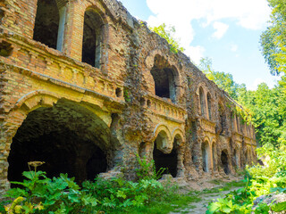 Ancient brick ruins of old fortification fort outpost. Monument of military history in Tarakaniv, Ukraine. Dubno fortress, ruined war fortification. Abandoned fortress outside, ruined wooded citadel.