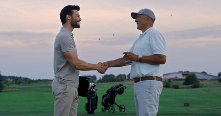 Golfing players make deal on green course field. Men sign document paper outside