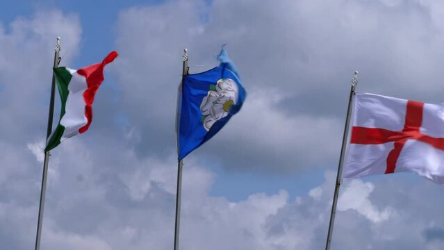 Flags of Yorkshire, Ireland and England blow on windy day