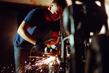 Motorcycle repair. Young man repairing motorbike in garage. Mechanic fixing motorcycle engine.