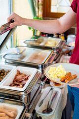 Food Buffet Catering Dining Eating Party Sharing Concept, Breakfast in the Luxury Restaurant, Man takes Food for Breakfast, Sausages, Becon and Eggs