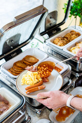 Food Buffet Catering Dining Eating Party Sharing Concept, Breakfast in the Luxury Restaurant, Man takes Food for Breakfast, Sausages, Becon and Eggs