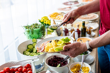 Food Buffet Catering Dining Eating Party Sharing Concept, Breakfast in the Luxury Restaurant, Man takes Food for Breakfast, Sausages, Becon, Eggs and Vegetables
