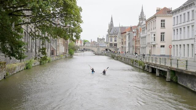 Two people kayaking on the Lys River downtown Ghent, Belgium - Wide angle