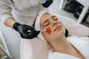 Close up of cosmetologist do beauty face procedures or treatment to woman client in aesthetic...